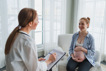 Female doctor examining pregnant woman in doctor office. Pregnant girl patient have consultation in...