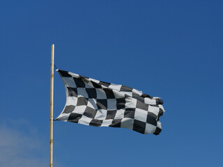 checkered flag waving in blue sky