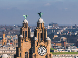Obraz premium Aerial view of Liverpool showcasing the Royal Liver Building with its clock towers and Liver Birds, surrounded by historic and modern city structures.