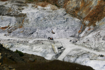 mining machinery in a huge wide open quarry with white stondes