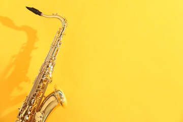 Golden saxophone on yellow background. Space for text