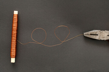 A coil of copper wire and pliers
