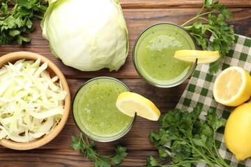 Healthy parsley drink in glasses, lemons and cabbage on wooden table, flat lay