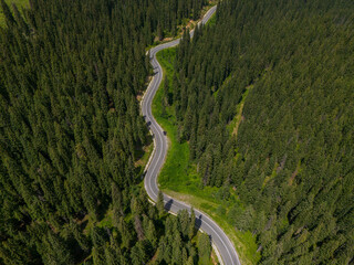 Curve asphalt road on mountain forest summer. Aerial view of the road passing through the mountain and green forest.