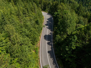 Curve asphalt road on mountain forest summer. Aerial view of the road passing through the mountain and green forest.