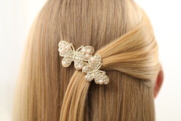 Woman with beautiful hair clip on blurred background, closeup