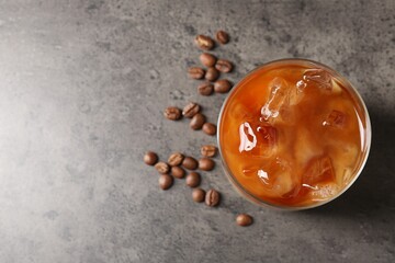 Tasty iced coffee and beans on grey table, top view. Space for text