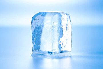 Cube of clear ice on light blue background