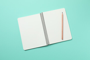 Top view photo of notebook with a pencil on color background with blank space. Business concept
