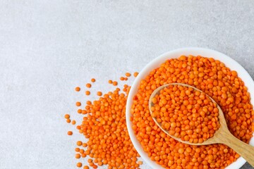 Red lentils in a bowl on a gray background