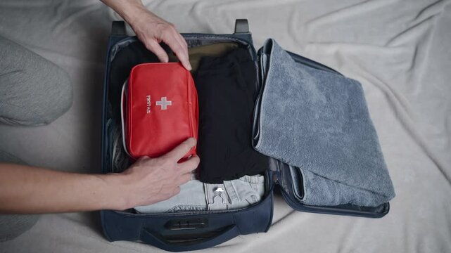 Demonstrating efficient packing techniques using a travel bag, including first aid supplies and clothing organization for a smooth journey