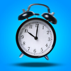 Black alarm clock ringing and jumping on blue background