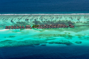 Generated imView of a turquoise coral reef and lagoon with a tropical paradise island and calm sea at the Maldives, Indian Ocean.age