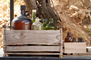 Empty glass bottles of various shapes, sizes, and colors arranged in wooden crates, promoting recycling, reuse, and environmental sustainability