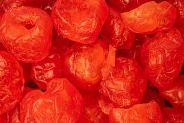 Macro close-up of bright red candied cherries, highlighting their glossy texture and vibrant color....