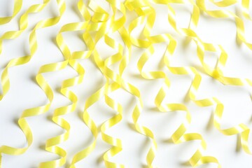Yellow serpentine streamers on white background, top view
