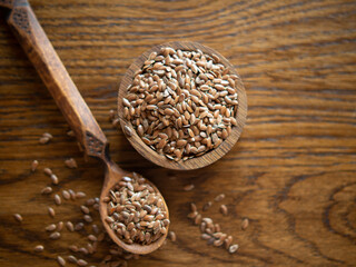 flax seeds in a rustic wooden bowl on a wooden table with copy space
