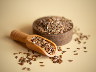 flax seeds in a wooden bowl on a beige background