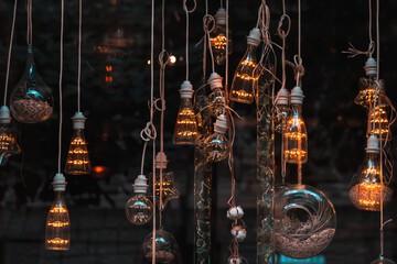 Hanging light bulbs illuminating dark background with plants