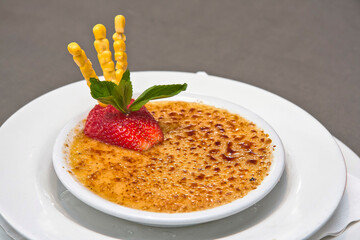 Corn creme brulee with strawberry, on a plate, crème brûlée dessert