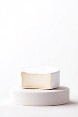 Circular Brie Cheese Cut Showing Soft Texture on a White Elevated Platform