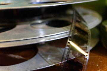Vintage film reels stacked on a wooden table showcasing cinema history
