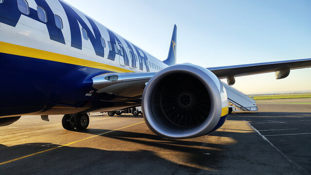 Airplane engine close-up at the airport during early morning light showcasing vibrant colors and detailed design elements