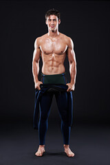 Fototapeta premium Studio, portrait of surfer or smile for sports, fitness and training for competition event. Professional athlete, male person or model and man with mockup, muscle or abs on dark background with pride