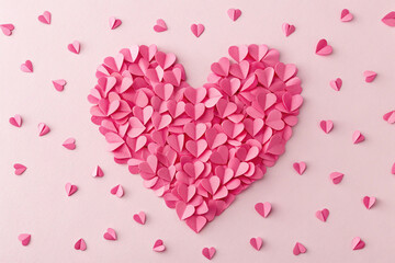 Obraz premium Heart Shape Made Of Many Paper Hearts On A Pink Background Overhead View