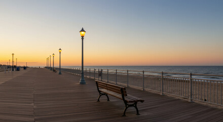 Obraz premium A quiet boardwalk at dusk lined with glowing lampposts, overlooking the calm ocean, evoking peace, nostalgia, and timeless beauty.