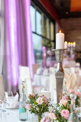 Elegant dinner setup featuring flowers and candlelight in a beautifully decorated venue for a special event