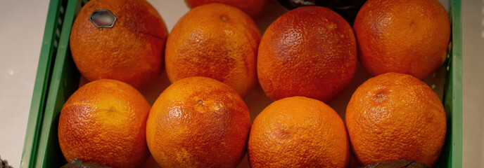 Fresh Blood Oranges Filling a Green Plastic Crate at the Market