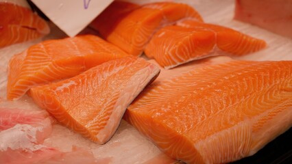 Fresh salmon fillets lying on ice in fish market
