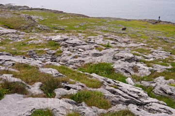 A rocky hillside with a body of water in the background