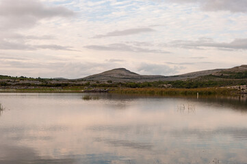A calm lake with a mountain in the background