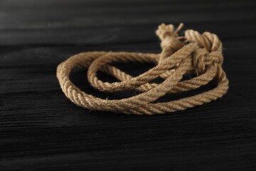 Cotton rope on black wooden background, closeup