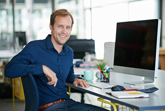 Man, desk and computer in portrait with smile in office with designer for creative project. Businessman, table and workstation with technology for web design with graphic for website with confidence