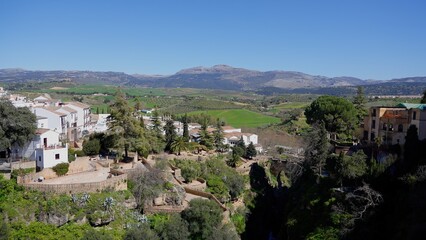 Ronda cityscape overlooking green valley and Serrania de Ronda mountains in Andalusia, Spain