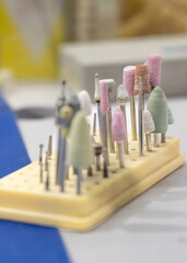 holder featuring an array of dental and rotary tool attachments, including polishing wheels, grinding stones, and brushes. Variety and precision emphasized