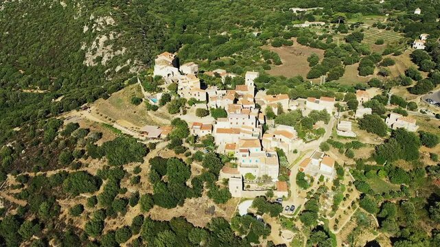 The town of Pigna stands between arid and green areas, in Europe, in France, in Corsica, on the edge of the Mediterranean Sea, in summer, on a sunny day.&nbsp;