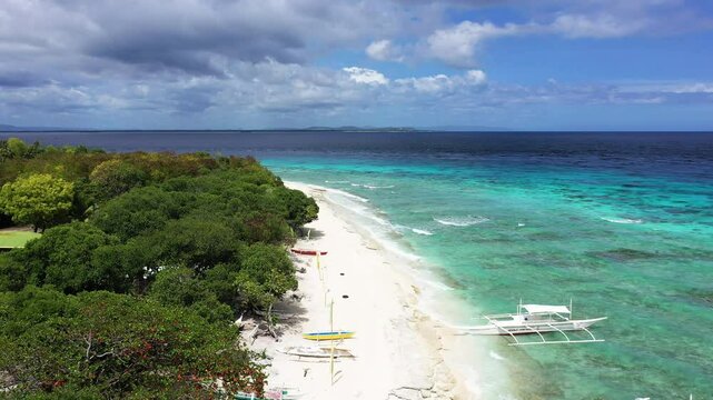 Moored boats arrive at the idyllic Balicasag Island, Asia, Philippines, towards Bohol Island, Panglao, in summer, on a sunny day.&nbsp;