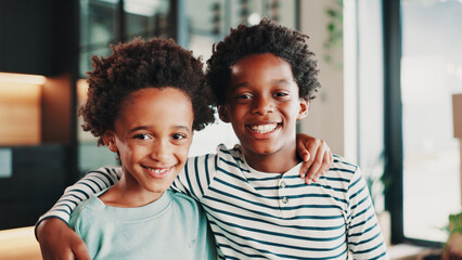 Fototapeta premium Happy, moving day and portrait of children hug in home with boxes for new house, apartment or rental. African family, real estate and kids ready for relocation for property, investment or purchase