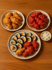 Feast of korean style fried chicken with sauce, Kimbap rolls and pickled radish on wooden tableGenerated image