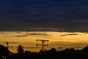 Silhouette of high voltage post on twilight sky background