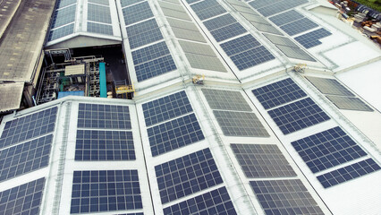 Obraz premium multiple solar panels installed on the rooftop of a building. The solar panels are arranged in neat rows and columns, with clear separations between each panel. 
