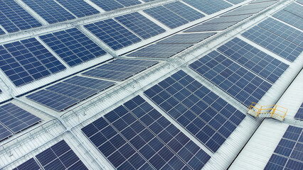Obraz premium multiple solar panels installed on the rooftop of a building. The solar panels are arranged in neat rows and columns, with clear separations between each panel. 