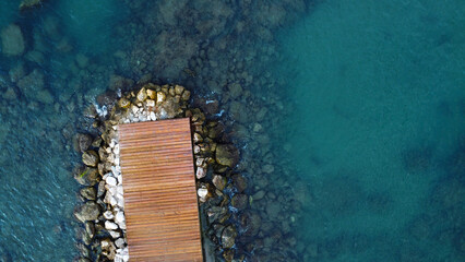 Aerial View of a Small Wooden Pier on a Rocky Shoreline