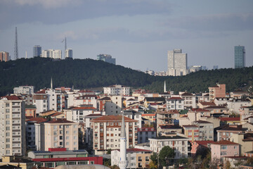 Naklejka premium Urban landscape view of buildings near hills in a bustling city