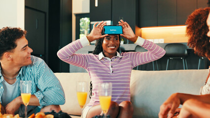 Acting, game and phone with friends in living room of home together for bonding or social...