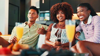 Drinks, watching tv and friends in home for relax, laughing and bonding with drama. Living room, group and happy people streaming television show for entertainment, comedy movie and social gathering